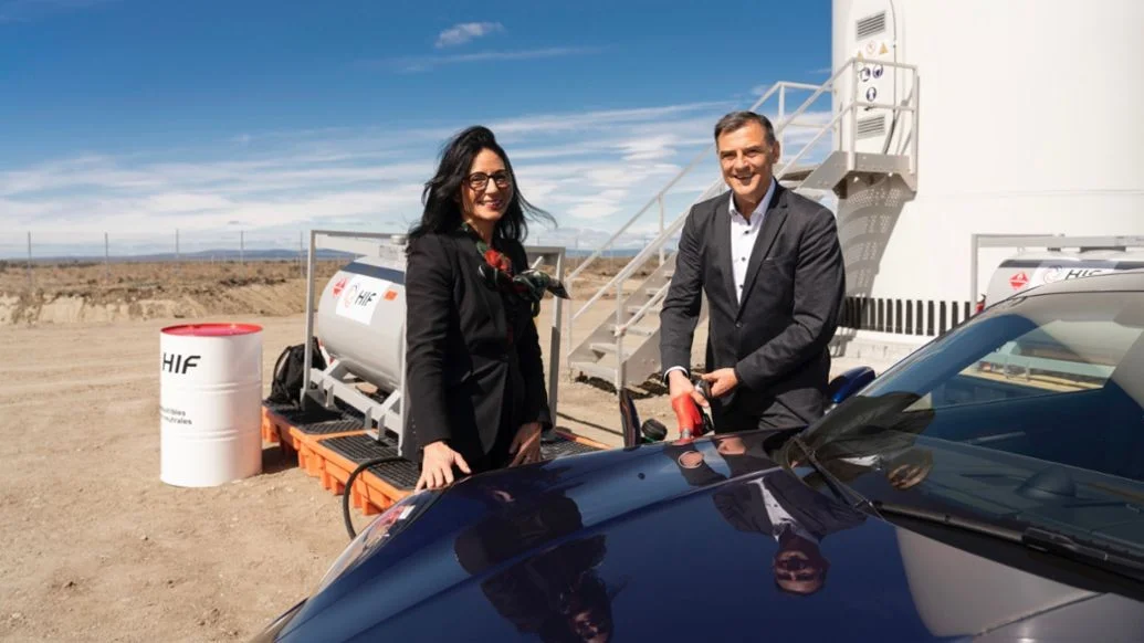 Barbara Frenkel and Michael Steiner ceremonially refueling a Porsche 911 with synthetic fuel at the Haru Oni plant in Chile