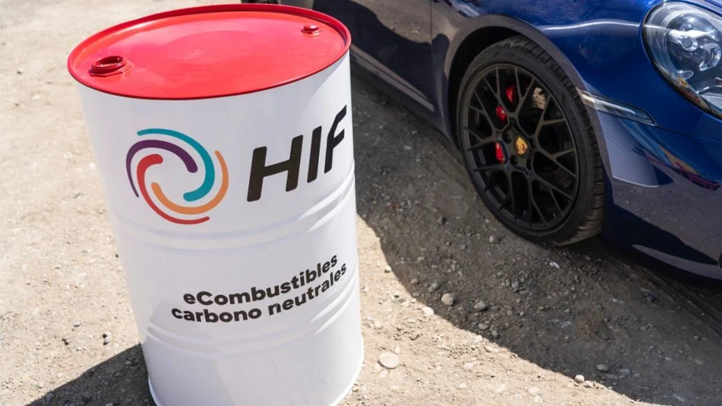 A Porsche 911 beside a barrel of HIF synthetic e-fuel produced at Haru Oni